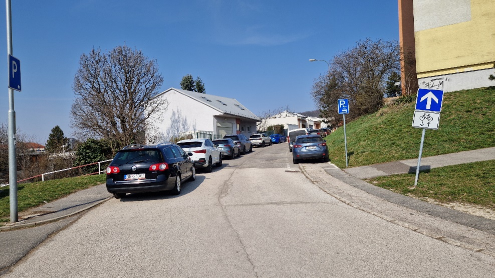 Ulica Klenová s parkujúcimi autami a dopravným značením